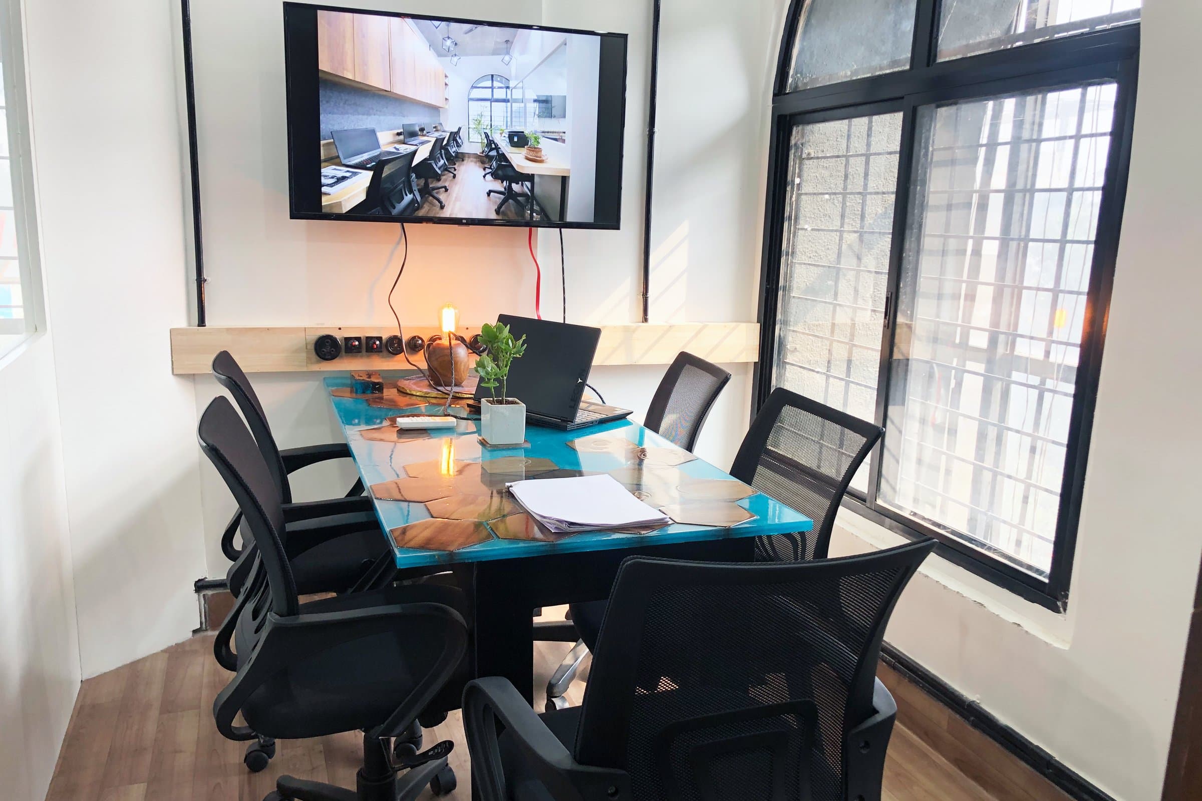 An industrial-loft studio anchored by a striking blue resin table — photo 14 of 16