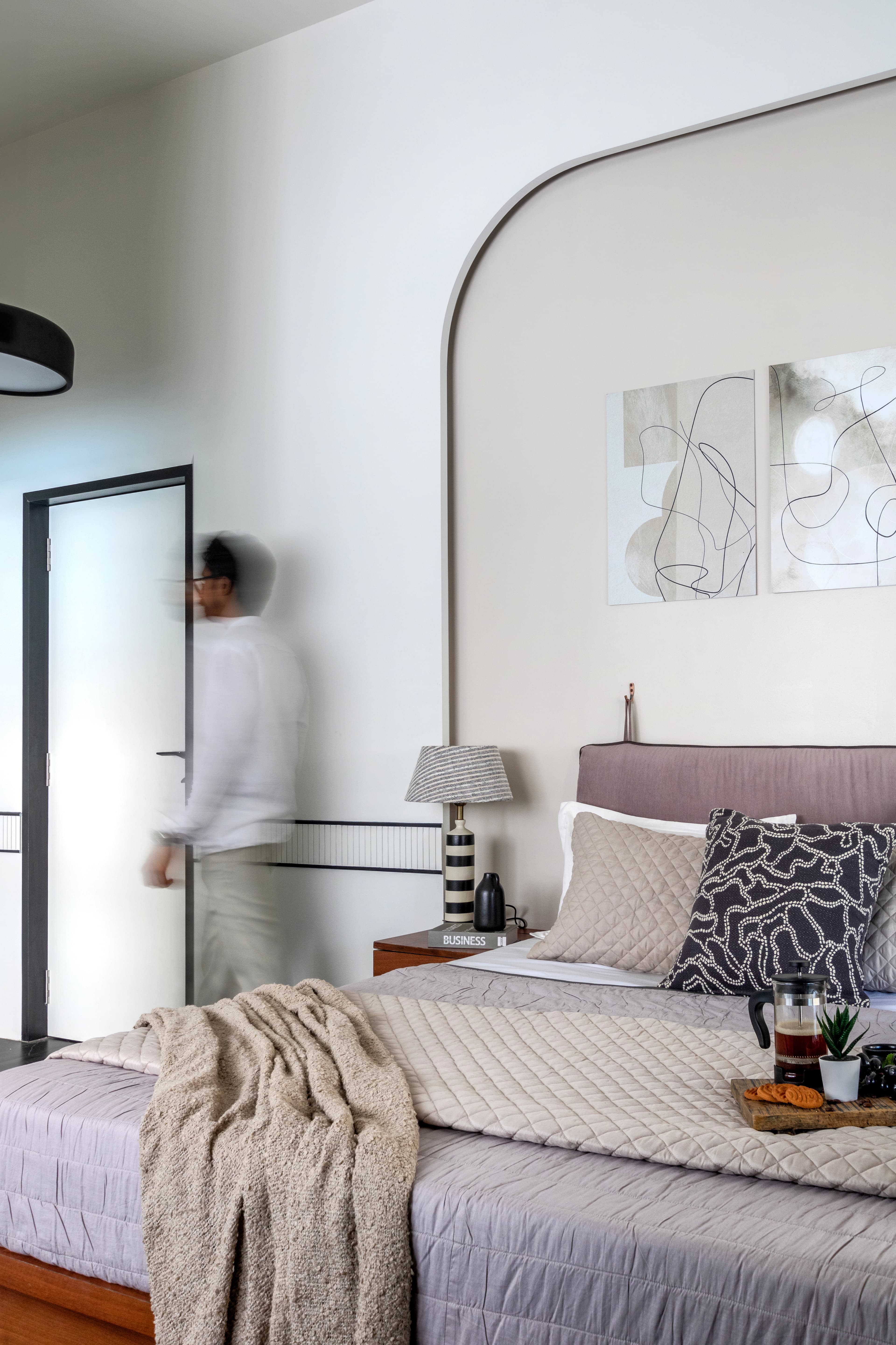 Project Ritu — motion-blur shot of a figure walking past the arched headboard wall